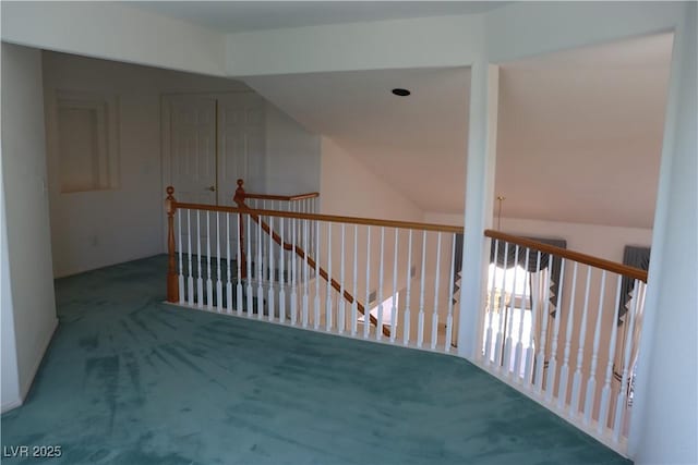 corridor featuring an upstairs landing and carpet flooring