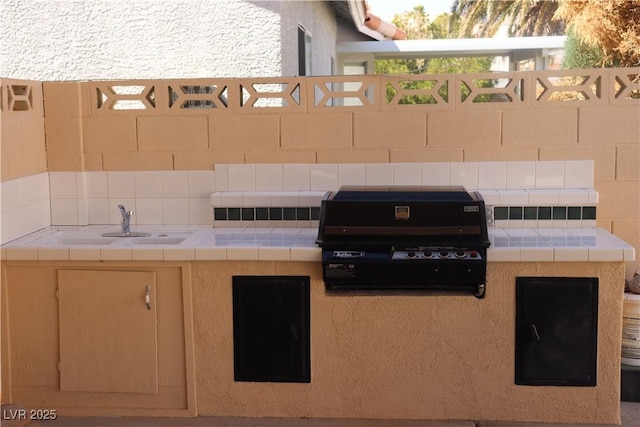 view of patio / terrace featuring a sink, fence, and a grill