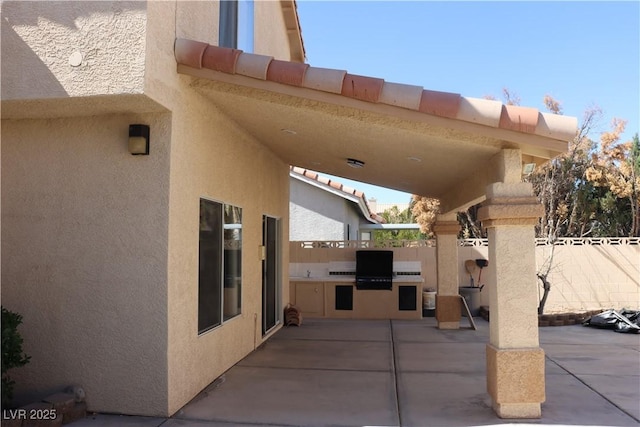 view of patio featuring area for grilling, a grill, and fence