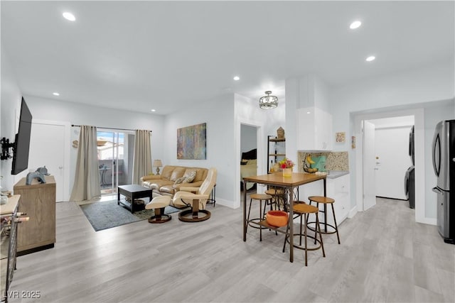 interior space with recessed lighting, washer / clothes dryer, light wood-type flooring, and baseboards