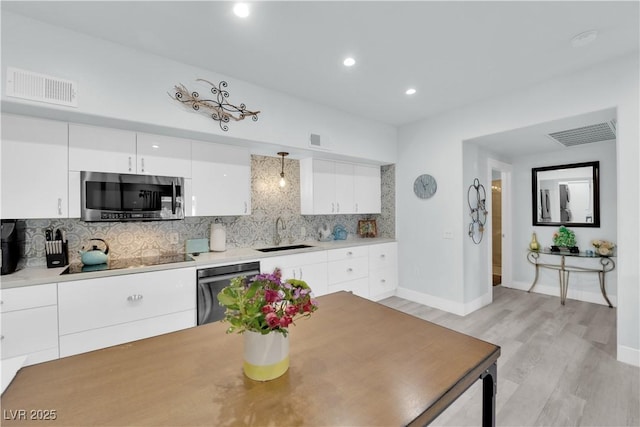 kitchen with visible vents, a sink, tasteful backsplash, appliances with stainless steel finishes, and white cabinets