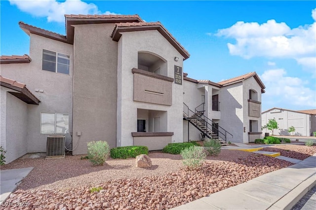 view of property with a residential view, central AC, and stairs