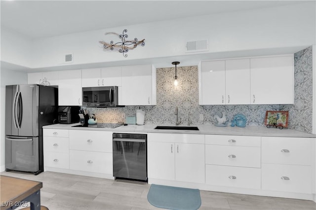 kitchen featuring visible vents, a sink, white cabinetry, appliances with stainless steel finishes, and light countertops