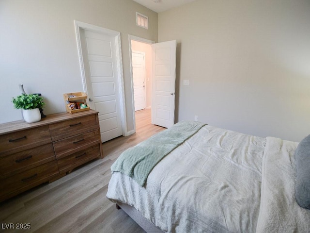 bedroom featuring wood finished floors and visible vents