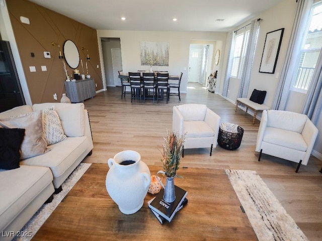 living room featuring light wood-style flooring, recessed lighting, and baseboards