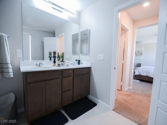 ensuite bathroom featuring double vanity, baseboards, ensuite bathroom, and a sink