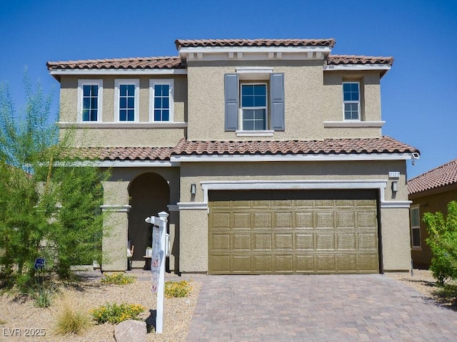 view of front of house with decorative driveway, a garage, and stucco siding