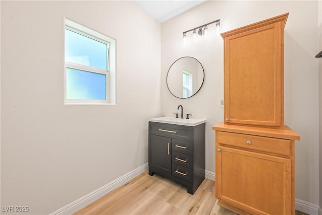 bathroom with baseboards, vanity, and wood finished floors