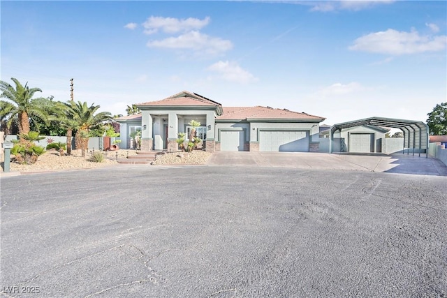 view of front of house with a detached carport, covered porch, a garage, and concrete driveway