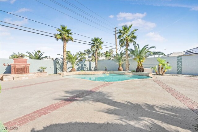 view of swimming pool featuring a patio area, a fenced in pool, fence, and exterior fireplace