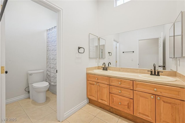 full bath with tile patterned floors, double vanity, a sink, and toilet