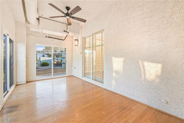spare room featuring wood-type flooring, a towering ceiling, and ceiling fan