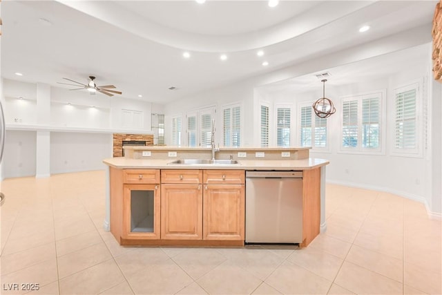 kitchen featuring recessed lighting, light countertops, a center island with sink, stainless steel dishwasher, and a sink