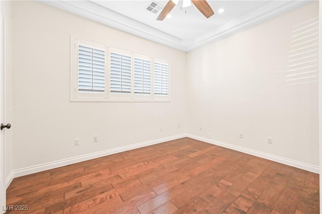 spare room with visible vents, baseboards, hardwood / wood-style floors, and ceiling fan