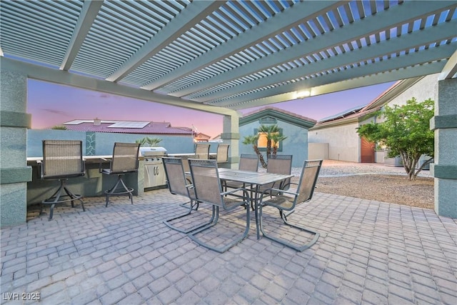 patio terrace at dusk featuring outdoor dining space and a pergola