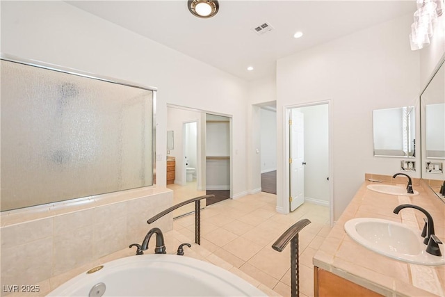 bathroom featuring a bath, a sink, visible vents, and a stall shower