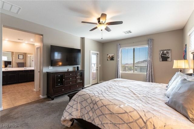 bedroom with tile patterned floors, visible vents, ensuite bathroom, and carpet flooring