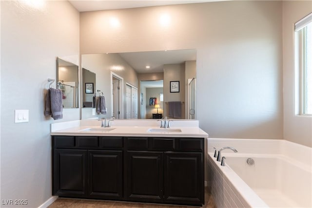 bathroom with a sink, a garden tub, and double vanity