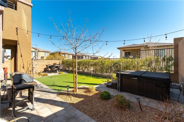 view of yard with a patio area, a hot tub, and a fenced backyard