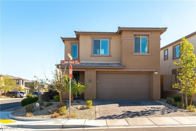 view of front of house with stucco siding, decorative driveway, an attached garage, and a tile roof