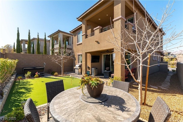 back of house with stucco siding, a fenced backyard, outdoor dining space, and a patio area