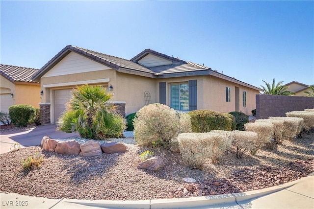 ranch-style home featuring stucco siding, concrete driveway, an attached garage, and fence