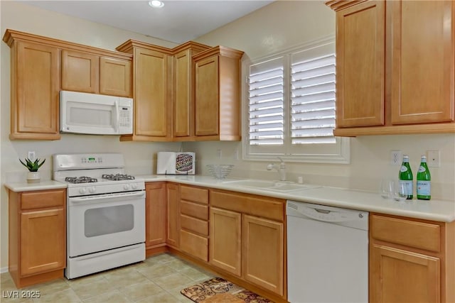 kitchen featuring white appliances, light tile patterned floors, light countertops, and a sink