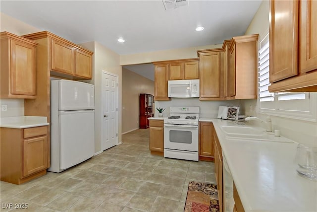 kitchen with a sink, visible vents, white appliances, and light countertops