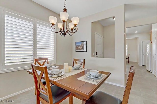 dining room featuring an inviting chandelier, light tile patterned floors, and baseboards