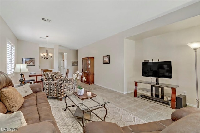 living room with vaulted ceiling, baseboards, visible vents, and a chandelier