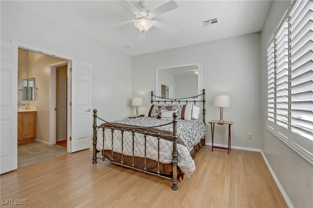 bedroom featuring connected bathroom, visible vents, baseboards, and light wood-style flooring