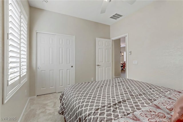 carpeted bedroom featuring a closet, visible vents, and multiple windows