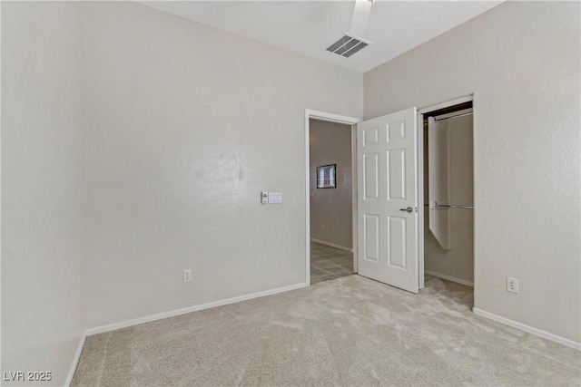 unfurnished bedroom featuring a closet, visible vents, baseboards, and carpet