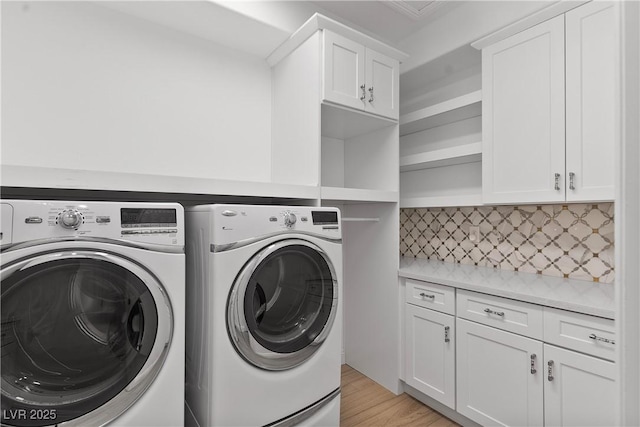 laundry area featuring cabinet space, washer and dryer, and light wood-type flooring