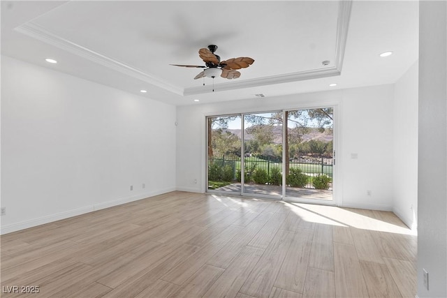 spare room featuring recessed lighting, light wood-style flooring, baseboards, and a tray ceiling