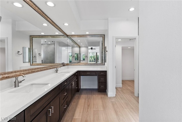 full bathroom with double vanity, recessed lighting, wood finished floors, and a sink