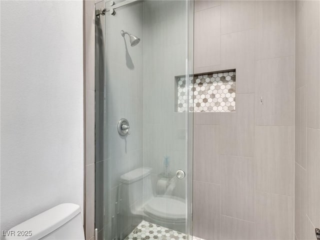 bathroom featuring a shower stall and toilet