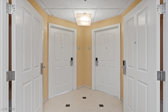 entryway with a drop ceiling and baseboards