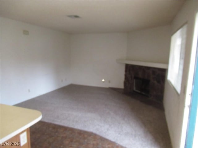 unfurnished living room featuring carpet flooring and a fireplace