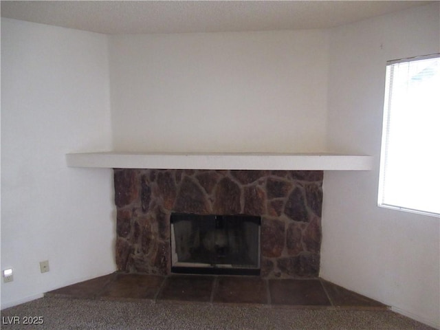 details with a stone fireplace and carpet flooring