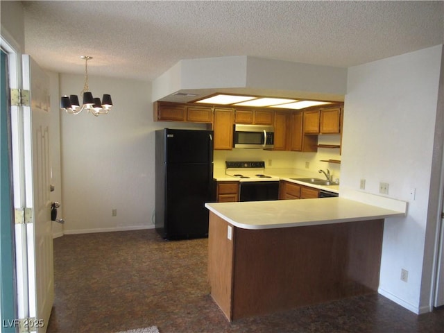 kitchen featuring stainless steel microwave, light countertops, a peninsula, freestanding refrigerator, and electric range