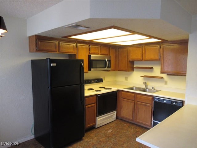 kitchen featuring black appliances, brown cabinetry, visible vents, and a sink