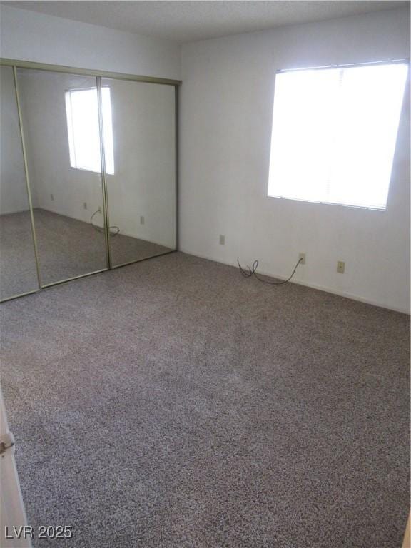 unfurnished bedroom featuring a closet and carpet flooring