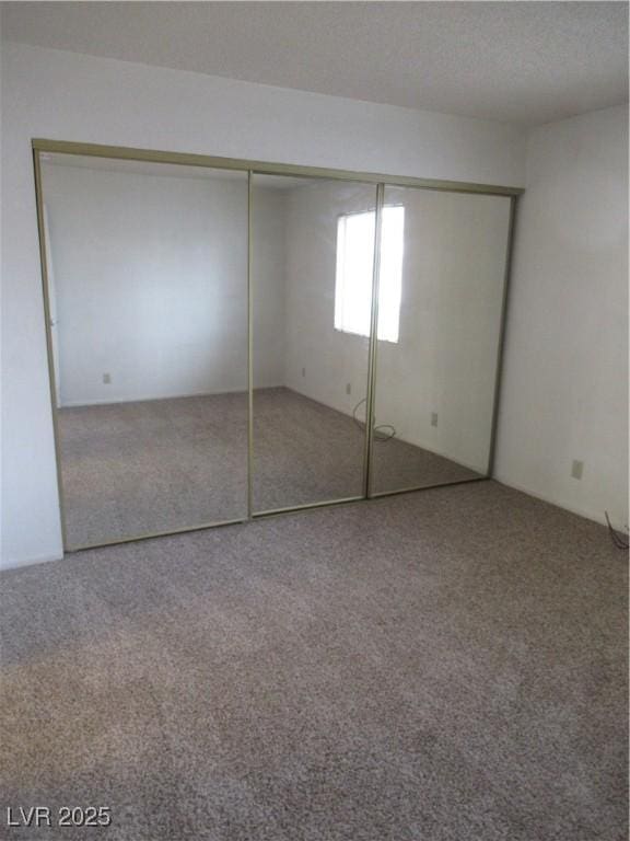 unfurnished bedroom featuring a closet, a textured ceiling, and carpet floors