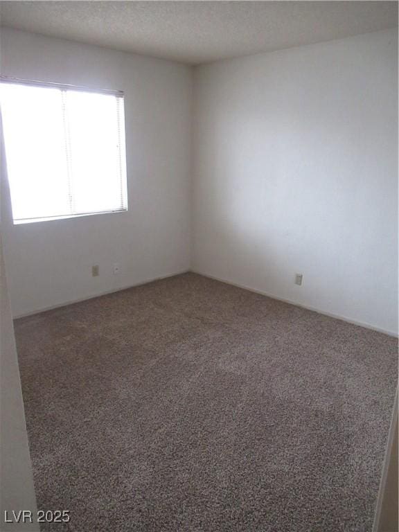 carpeted spare room with a textured ceiling