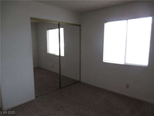 unfurnished bedroom featuring multiple windows, a closet, and carpet floors