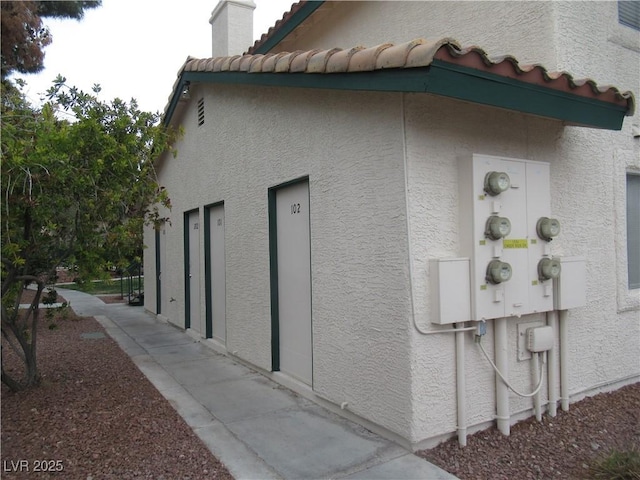 view of home's exterior with stucco siding and a tile roof