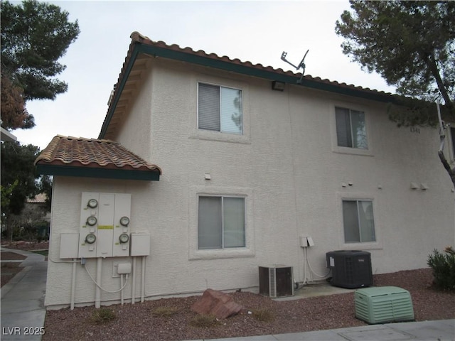 back of house featuring central AC and stucco siding