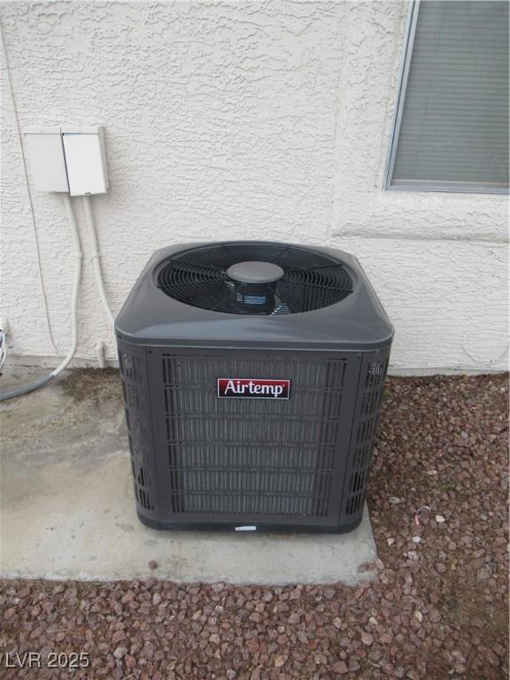 exterior details featuring central AC unit and stucco siding