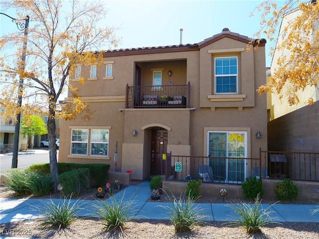 mediterranean / spanish-style home featuring a balcony and stucco siding